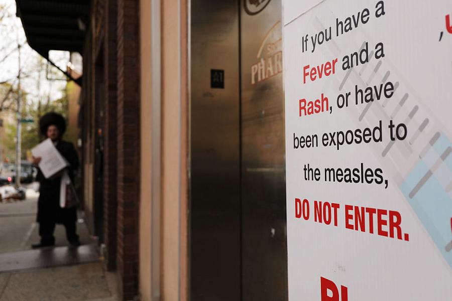 A sign warns people of measles in the ultra-Orthodox Jewish community in Williamsburg in New York City. (Photo by Spencer Platt/