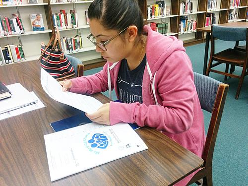 DACA recipient Stephanie Martinez reviews the Medi-Cal documents she received by mail. (EGP photo by Jacqueline Garcia)
