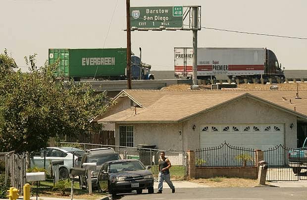 Big rigs travel along Highway 60 near Mira Loma Village homes in Jurupa Valley. Traffic has increased greatly since the housing tract was built, residents say.