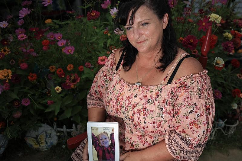 Brenda Wezowicz holds a photo of her granddaughter, Karma Wezowicz, as she sits in front of a buttefly garden she and Karma had planned together and is dedicated to Karma. Karma was accidentally shot in late February 2017 and died a few days later.