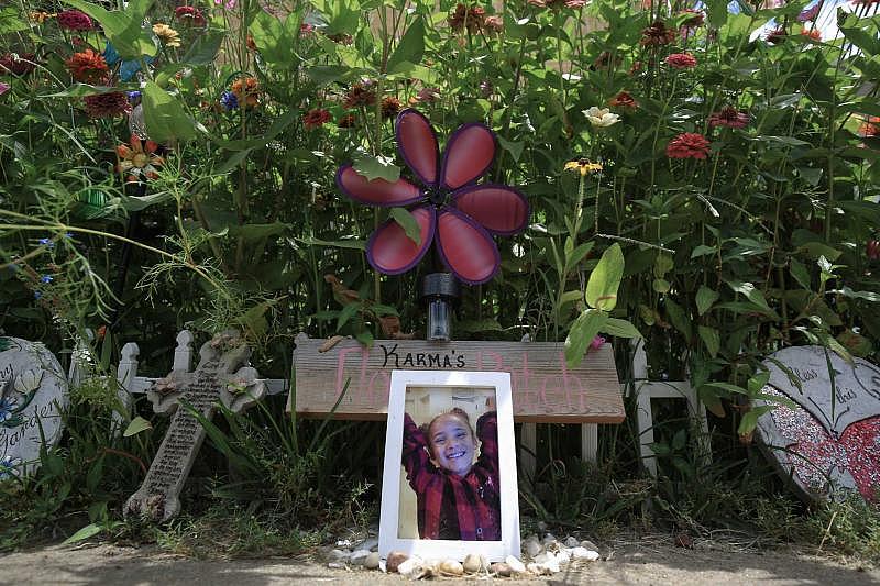A photo of Karma Wezowicz sits in front of a buttefly garden that Karma and her grandmother, Brenda Wezowicz, had planned together before the 7-year-old was accidentally shot in late February 2017. She died a few days later, and the garden grows in her memory.