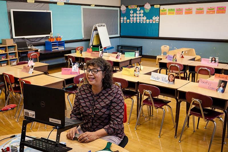 En septiembre, Olga Contreras comenzó a enseñar a sus estudiantes de forma remota desde su salón de clases en Saucedo Scholastic Academy. Ella no tiene un escritorio de maestra porque normalmente camina todo el día. Este otoño, se sentó en una mesa para niños. (Michelle Kanaar / WBEZ)