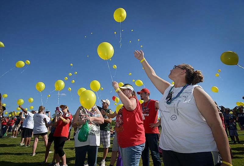Emily Marie Rogers (right) and her mother, Cindy Lee Rogers of Springdale, join others in releasing balloons during the annual Northwest Arkansas Out of the Darkness Community Walk in 2016 at Orchards Park in Bentonville. The balloons were released in memory of loved ones who died by suicide. (NWA Democrat-Gazette/Ben Goff)