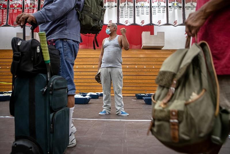 Johnny Alvarez, 47, center, motions to his mother upon checking into the emergency overnight shelter run by the Coachella Valley Rescue Mission inside a portion of the Palm Springs High School Gymnasium on Saturday , June 27, 2020. Taya Gray, Taya Gray Johnny Alvarez, 47, center, motions to his mother upon checking into the emergency overnight shelter run by the Coachella Valley Rescue Mission inside a portion of the Palm Springs High School Gymnasium on Saturday , June 27, 2020. Taya Gray, Taya Gray