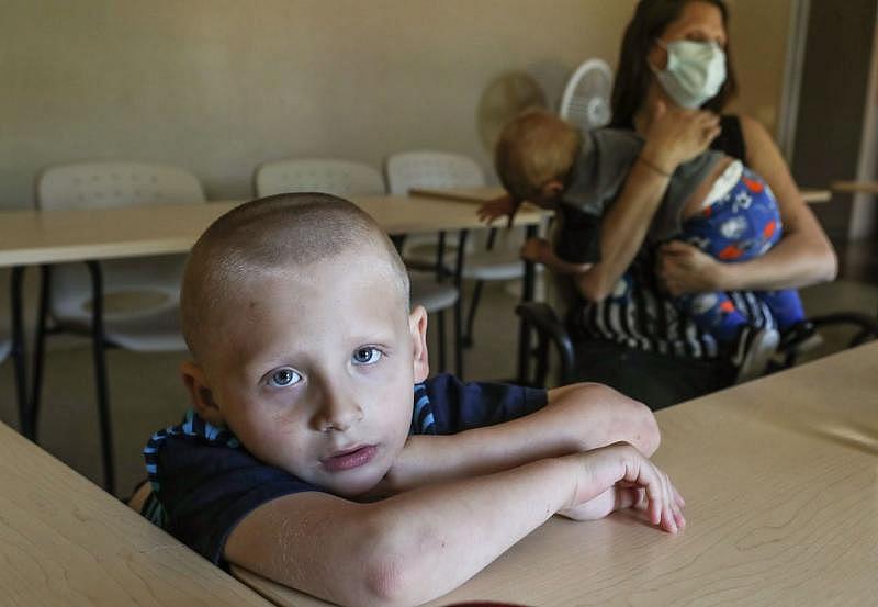 Zechariah Delavern, 5, stares into the camera as his mother Cindy Fadness has her hands full with her one-year-old son Jeremiah Delavern as they live in quarantine at the Coachella Valley Rescue Mission in Indio, April 16, 2020. Jay Calderon/ The Desert Sun
