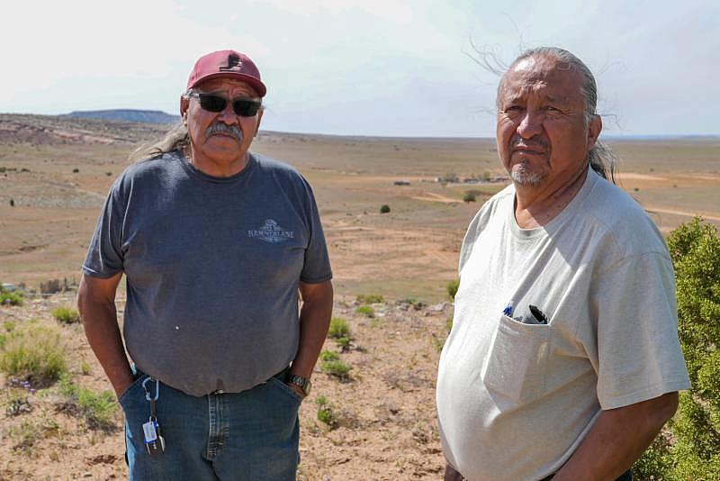Henry Tso and Arnold Slowman, a local leader in the Tolikan chapter — a town-like designation within Navajo Nation — stand on a hilltop overlooking the reservation. Photo: Eli Cahan.