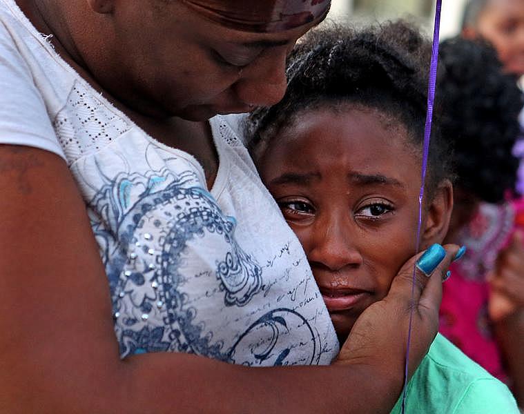 “I was her best friend. She was like my sister,” says Akeelah Kelly, 8, who finds comfort in her mother’s arms during a vigil in Ferguson for Jamyla Bolden, 9, in August. Jamyla was one of the first girls to introduce herself when Akeelah moved to Ellison Drive with her mom and sister.