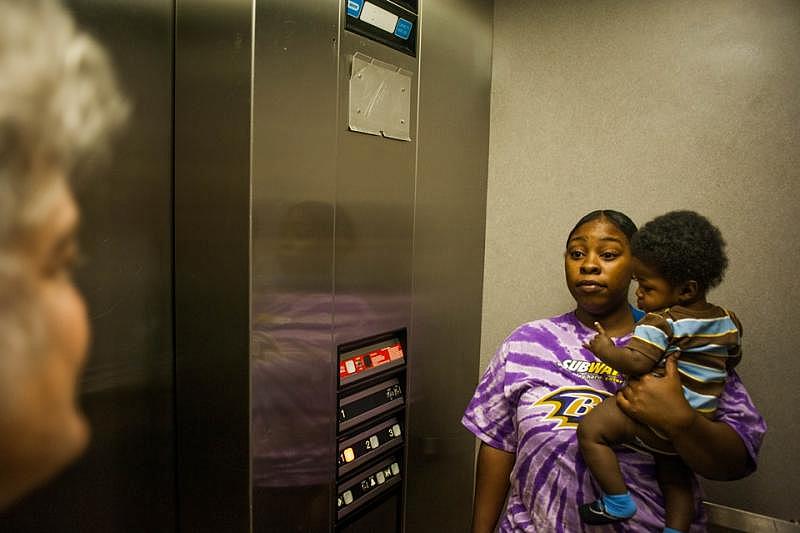 Cierra rides the elevator with Audrey Leviton, the director of PACT. (Noah Scialom / The Atlantic)