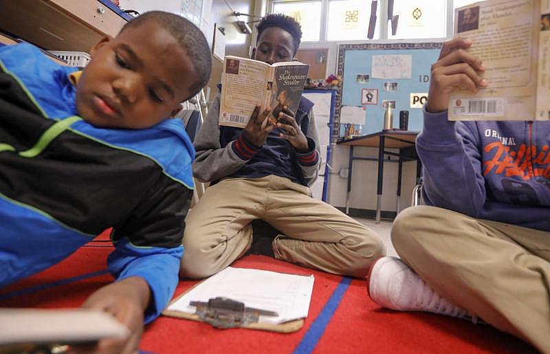 Panthers teammates Michael Pollard, left, and Devin Clayton, center, read during class at KIPP Central City Primary.