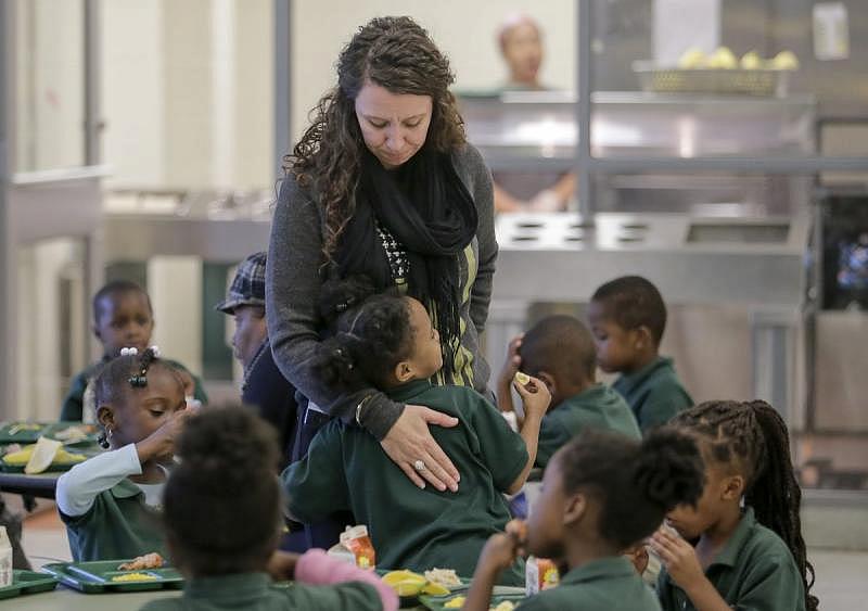Lawrence D. Crocker College Prep counselor Rochelle Gauthier gets a hug from a student during lunch at the school in New Orleans.