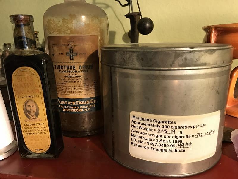 Lonnie Painter collects antique opioid- and cannabis-based tinctures. The large tin is from an experimental federal program that provides marijuana pre-rolls to selected patients around the country.