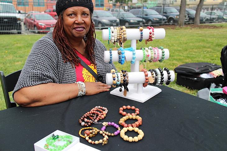 Oakland resident Cassandra Hughes works for Room to Bloom and also sells her jewelry at the market. (Priska Neely/KPCC)