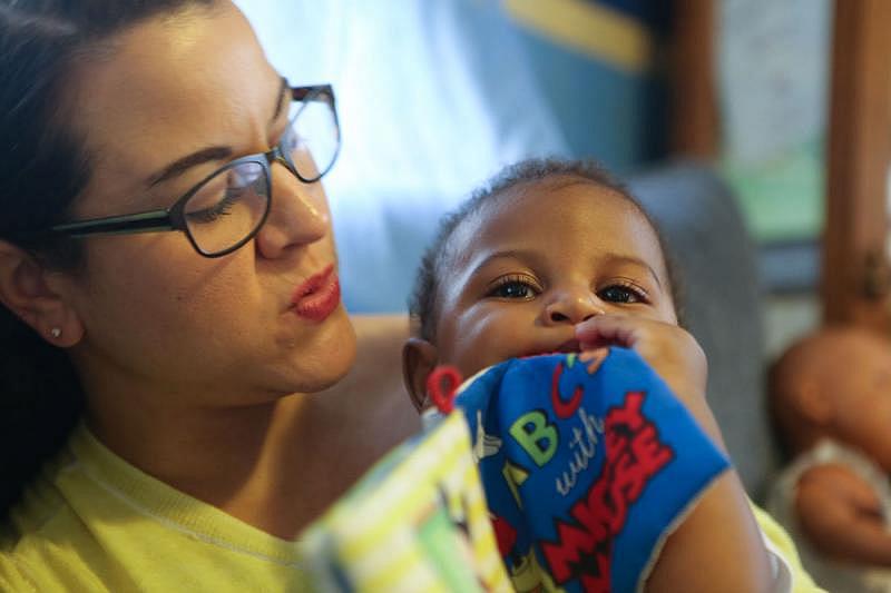Nurse-Family Partnership nurse Amber Burleson plays with 6-month-old Kai'Dian Gomes. 