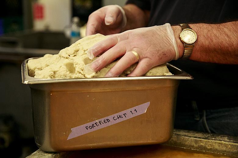 Dunn prepares to load corn-masa dough fortified with folic acid into the hopper of a tortilla maker. (Erika Schultz / The Seattle Times)