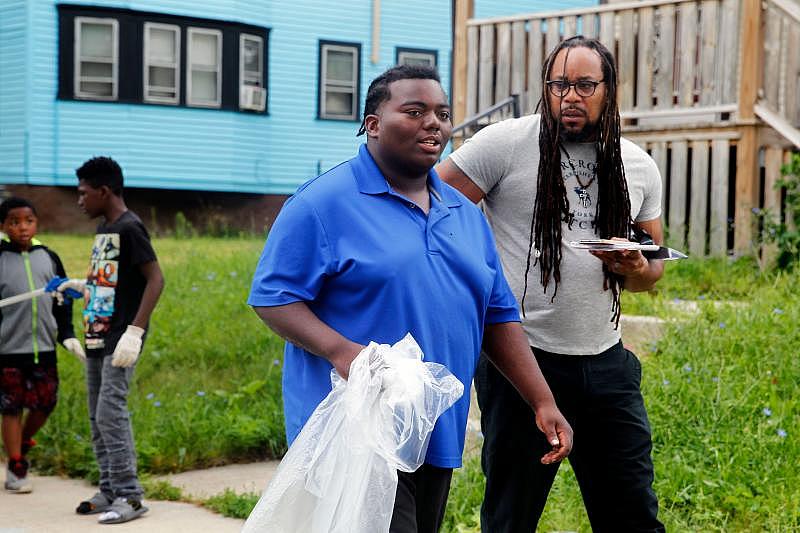 Special projects reporter James E. Causey talks with Marshawn Dixon, 19, who has been in the urban gardening program for years. Dixon said cleaning up his neighborhood gives him a sense of pride.