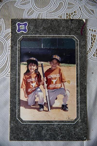 Theresa Martinez shows old photographs of her kids in Little League. (Photo: Angela Piazza/Victoria Advocate) Theresa Martinez shows old photographs of her kids in Little League.
