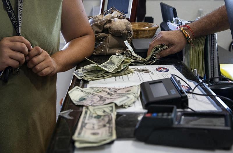A motel manager counts $84.75 for a room with two queen beds and a pullout. He was hesitant to rent to Orsak because he said the motel, located on the outskirts of town, was almost at capacity. After paying for the room, Orsak had $13 left to feed herself and seven kids. (Photo: Angela Piazza) A motel manager counts $84.75 for a room with two queen beds and a pullout. He was hesitant to rent to Orsak because he said the motel, located on the outskirts of town, was almost at capacity. After paying for the room, Orsak had $13 left to feed herself and seven kids.