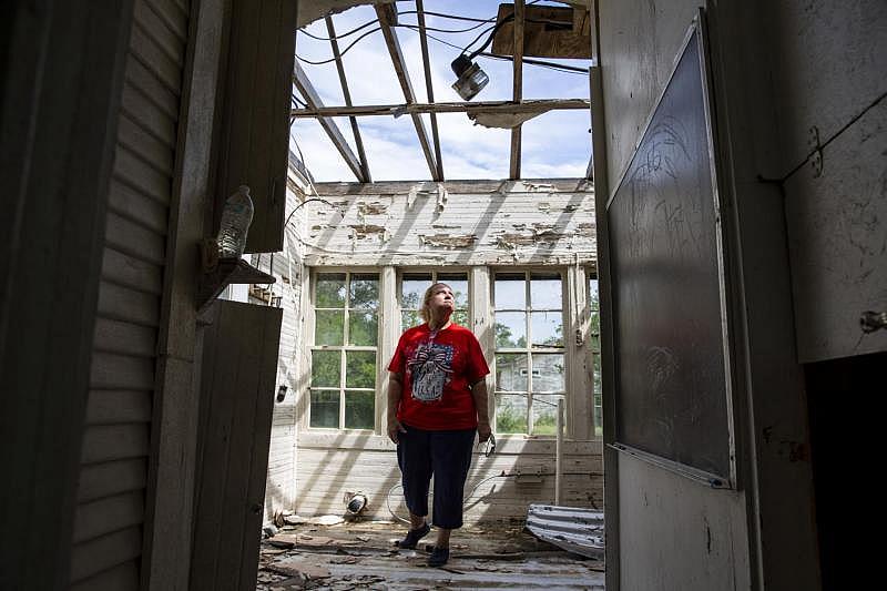 While revisiting her wrecked Bayside home, Sabine Wiegand stands in the foyer and looks up through the hole in her roof for a portrait. Town officials said about 50 homes were destroyed in the storm, driving an unknown number away permanently. (Photo Credit: Angela Piazza/Victoria Advocate) While revisiting her wrecked Bayside home, Sabine Wiegand stands in the foyer and looks up through the hole in her roof for a portrait. Town officials said about 50 homes were destroyed in the storm, driving an unknown number away permanently.