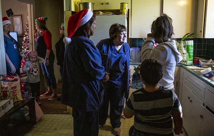 Margie Johnson, 60, and Janet Hilsabeck, 59, speak with Cindy Barrientes, who wipes a tear off her face in her kitchen. Her son, Jonathan Sanchez Jr., 6, stands behind her. Johnson and Citizens Medical Center’s Birth Center colleagues collected and delivered household items, Christmas presents and more to the family. (Photo Credit: Angela Piazza/Victoria Advocate) Margie Johnson, 60, and Janet Hilsabeck, 59, speak with Cindy Barrientes, who wipes a tear off her face in her kitchen. Her son, Jonathan Sanchez Jr., 6, stands behind her. Johnson and Citizens Medical Center’s Birth Center colleagues collected and delivered household items, Christmas presents and more to the family.