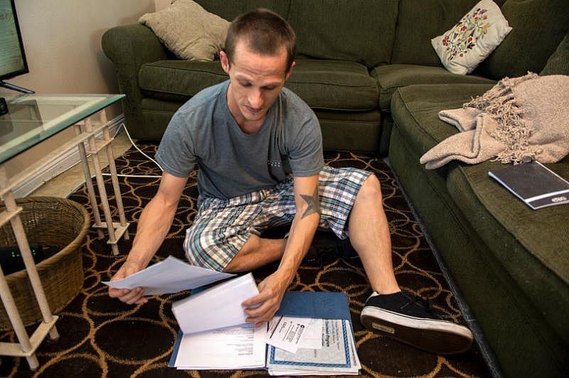 Jeremy Jones sorts through his certificates of sobriety that he keeps in a folder at his Anaheim apartment on Saturday, October 20, 2018. He hopes to get a job in food service. (Photo by Mindy Schauer, Orange County Register/SCNG)
