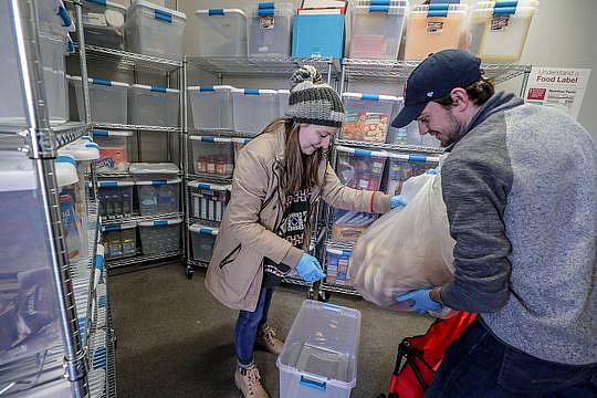 Henny Ransdell, left, and Ryan Buckman, right, take a bag of bagels donated by Einstein Bros. bagels, and put them into a plastic bin at U of L's food bank. Jan. 28, 2019 (Photo Credit: Michael Clevenger/Courier Journal) Henny Ransdell, left, and Ryan Buckman, right, take a bag of bagels donated by Einstein Bros. bagels, and put them into a plastic bin at U of L's food bank. Jan. 28, 2019 (Photo: Michael Clevenger/Courier Journal)