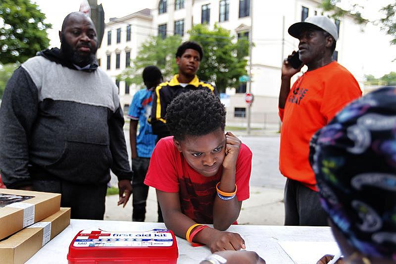 Jahiem Greer, 13, (center) signs in at the garden. If the boys arrive one minute pass 8 a.m., they are considered late. Many start lining up as early at 7:30 a.m.