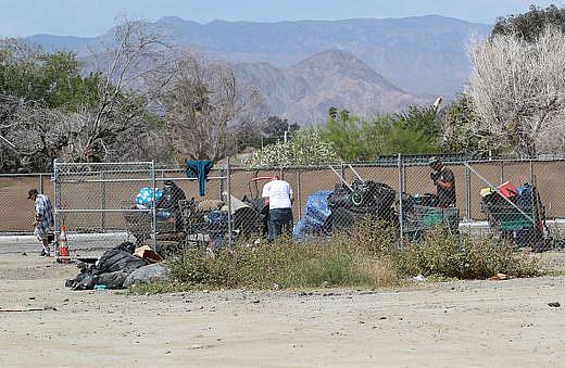 People experiencing homelessness prepare to move their camps and belongings off of a large vacant lot. (Jay Calderon/The Desert Sun)