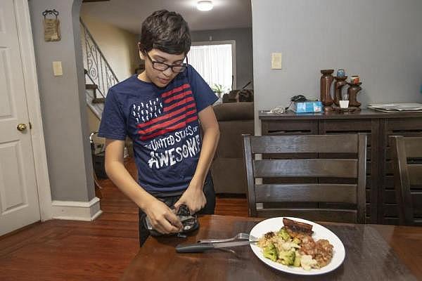MICHAEL BRYANT / STAFF PHOTOGRAPHER David Garcia, 12, pricks his finger in order to take a reading of his blood sugar levels before he sits down to eat his dinner.
