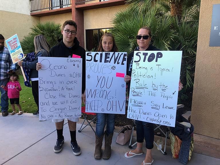 People with signs outside the Embassy Suites in San Luis Obispo before the start of the California Coastal Commission meeting on Thursday. Ashley Ladin ALADIN@THETRIBUNENEWS.COM
