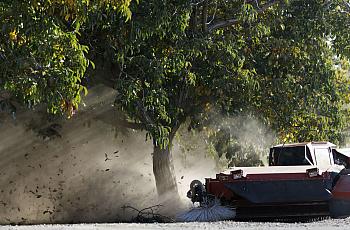 An image of a tractor blowing dust in the farm.