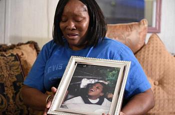Jessie Evans becomes emotional as she holds a portrait of her son, Cornelius James Evans, taken when he was 5 years old, at her home in Donalsonville, Ga. JON-MICHAEL SULLIVAN/STAFF