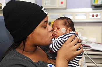 Alaina Gonville kisses her 3-month-old Brandon at the Neonatal Intensive Care Unit at Hutzel Women's Hospital in Detroit. Brandon was born premature through an emergency C-section. (Max Ortiz / The Detroit News)  