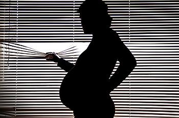 pregnant woman looking out of window