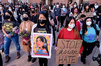 Demonstrators wearing face masks and holding signs take part in a rally to raise awareness of anti-Asian violence 
