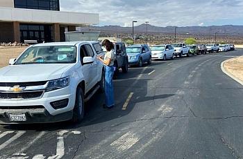 A line of more than 30 cars await a food distribution event to begin at Copper Mountain College in Joshua Tree on Aug. 2, 2022. 