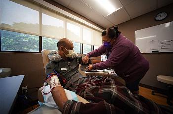 Kim Pagan adjusts her husband’s blood pressure device as he practices on the in-home dialysis machine. 