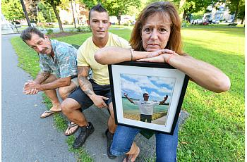 Lynne Russell, of Hawley Pa., holds a photo of her late son, Patrick, on July 25, 2019, as she sits with her husband Patrick.
