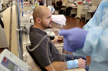 Dustin Wallis, a 39-year-old nonsmoker, receives an infusion to treat stage 4 lung cancer at Utah Cancer Specialists in South Sa