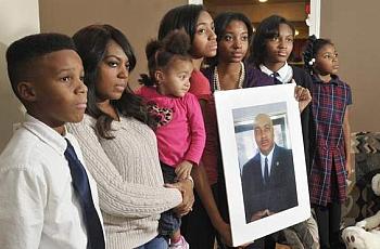Many families in Detroit must cope with the slaying of a family member. Marcel Jackson was killed while working as a security guard, leaving behind, from left, Tarik, 13; wife Hollie holding Aaliyah, 2; Jala, 16; Najidah, 18; Tamia, 13; and Gwendolyn, 7. (Photos by Max Ortiz / The Detroit News)  