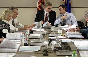 Dr. Sheldon Wasserman, center, chairman of the Wisconsin Medical Examining Board, talks with Tom Ryan, right, executive director of the board. On the left are board members Jude Genereaux and Dr. Gene Musser. The 13-member board, appointed by the governor, includes 10 doctors and three public members.  