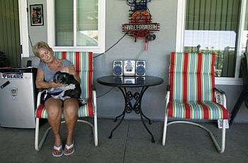 Mary Buffum, 65, of Fontana sits with her dog, Cash, next to her late husband Jack's chair on the patio where they loved to entertain family and friends. Jack Buffum, 59, was killed May 30, 2013, in a workplace accident in Rialto.