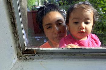 Guadalupe Vargas with her daughter Jaylani, 1, outside their mold covered bedroom window at the Walnut Creek Apartments.