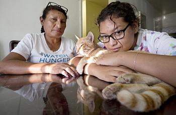 Orange Chicken the cat enjoys the late afternoon sun with his owner Carolina Torres and her mother Margarita Montes.