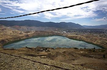 The toxic Berkeley Pit, shown here with the city of Butte in the background, is part of the largest Superfund site in the United