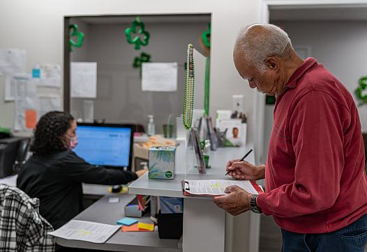 A man fills out paperwork at the doctor's office.