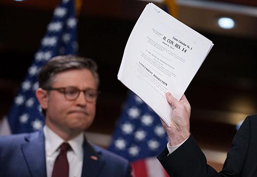 House Majority Leader Steve Scalise, accompanied U.S. Speaker of the House Mike Johnson, holds up their budget resolution bill as he speaks during a news conference following a House Republican caucus meeting at the U.S. Capitol on February 25, 2025 in Washington, D.C.