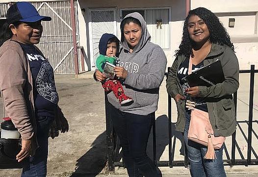 Tres mujeres de pie juntas con un bebé.