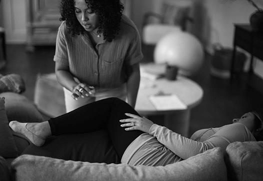 One person sleeping on couch other standing near them