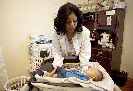 Flossie Horace takes oxygen levels and weighs her 3-month-old grandson every morning in her Roanoke home.