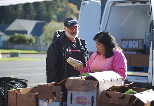 Shayne Britt and Roxie Reyes examine a delicata squash at an October visit of Food For People's Mobile Produce Pantry to Klamath